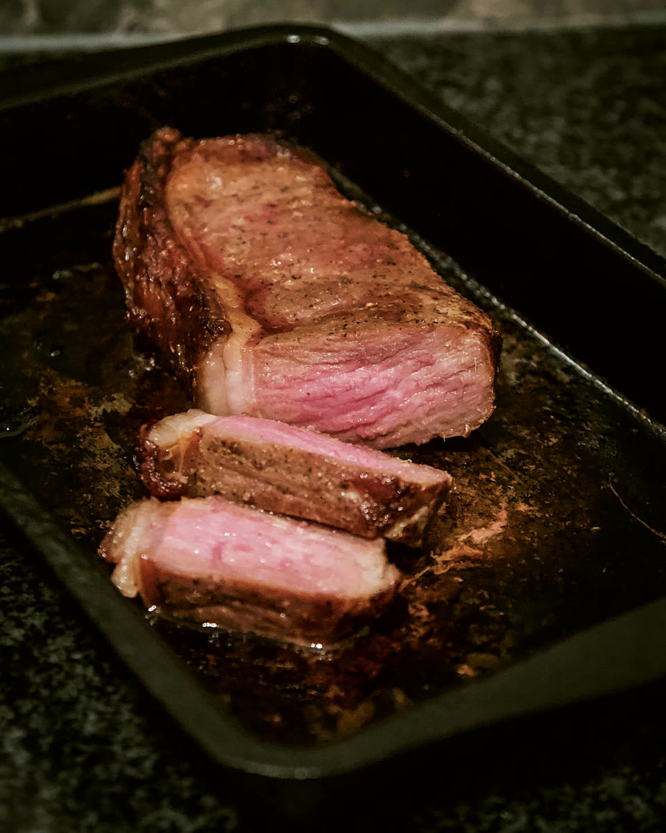 Striploin sliced in a dark tray