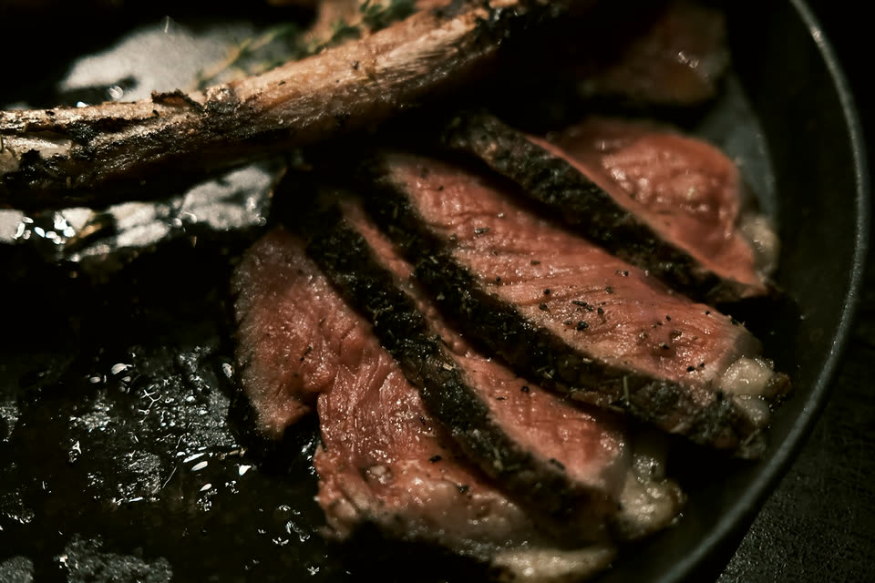 Tomahawk steak sliced in a cast iron pan